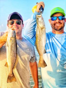 Two men holding up Speckled Trout.